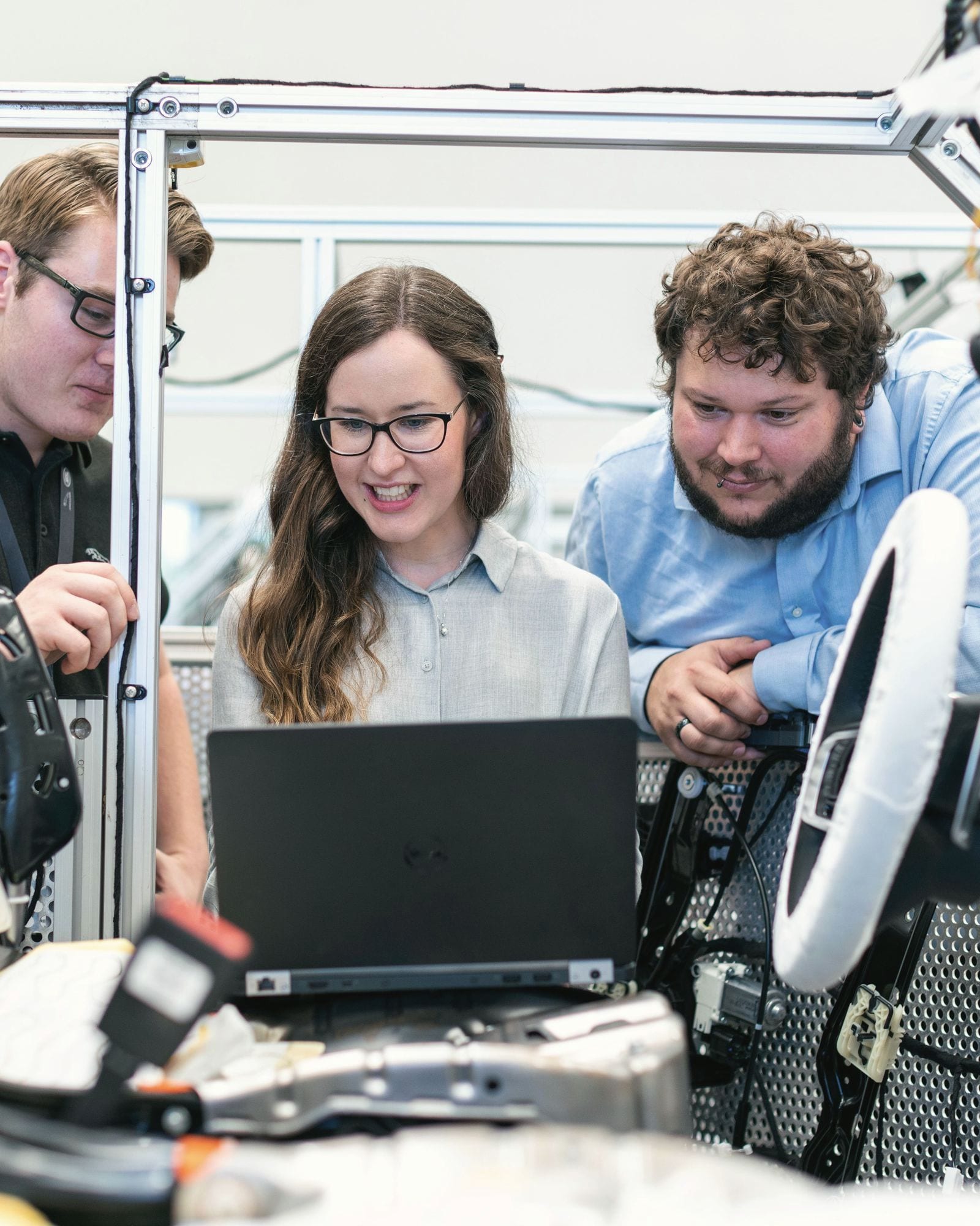 Three engineers reviewing data on a laptop