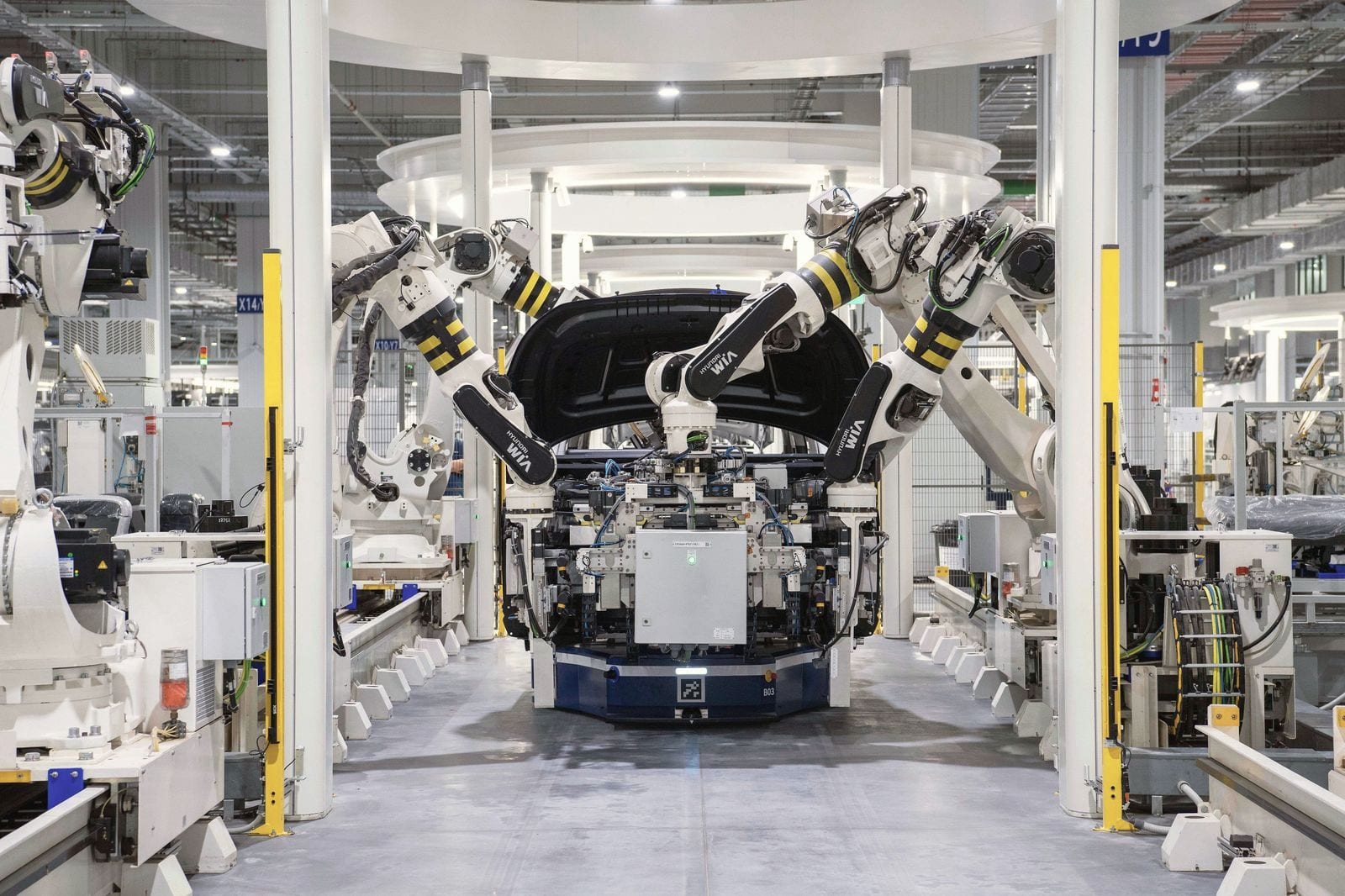Robot arms working on a vehicle body on an assembly line